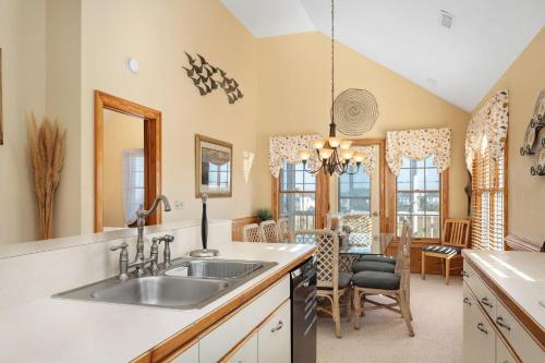 a kitchen with a sink and a dining room at W13 Wedges 13 in Nags Head