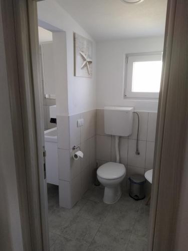 a white bathroom with a toilet and a sink at House Munich - Montenegro in Donji Štoj