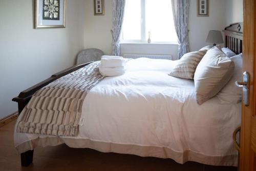 a bedroom with a large bed with white sheets and pillows at The Scotch Rock in Castlewellan
