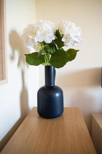 a blue vase with white flowers sitting on a table at The Scotch Rock in Castlewellan