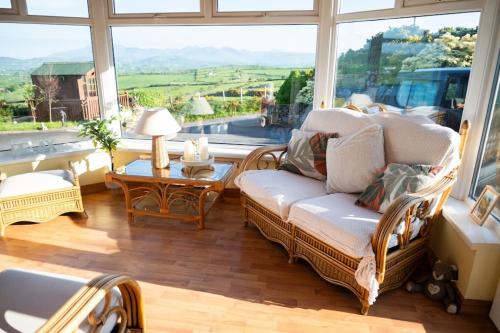 a living room with a couch and a large window at The Scotch Rock in Castlewellan