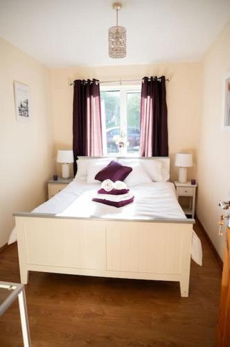 a bedroom with a white bed with a window at The Scotch Rock in Castlewellan