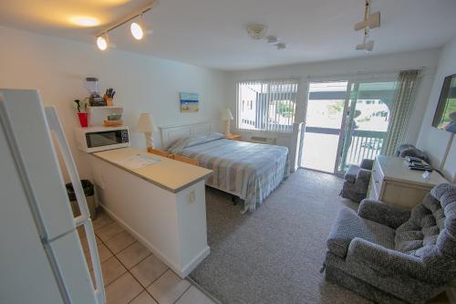 a bedroom with a bed and a desk and chairs at Eastwood at Provincetown in Provincetown