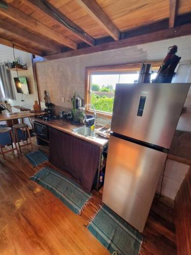 a kitchen with a stainless steel refrigerator in a room at Chalé SZ Pantanal in Cáceres