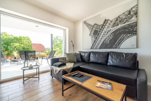 a living room with a black leather couch and a table at Peter`s Lucky Home Balaton, Vonyarcvashegy in Vonyarcvashegy
