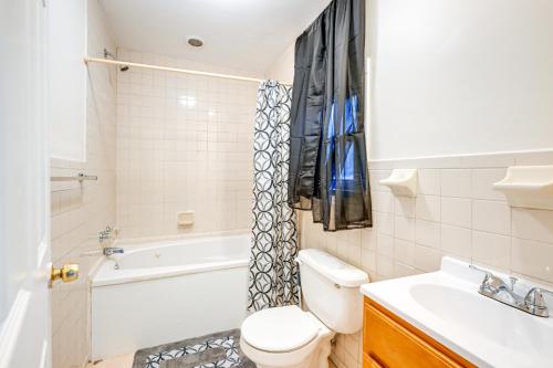 Un baño con inodoro, bañera y lavabo. en Charming Long Island Home with Fenced Yard!, en Freeport