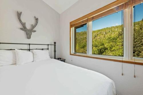 a bedroom with a white bed and a window at The Charter at Beaver Creek D455 in Beaver Creek