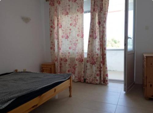 a bedroom with a bed and a window with curtains at Wild house Goriza in Goritsa
