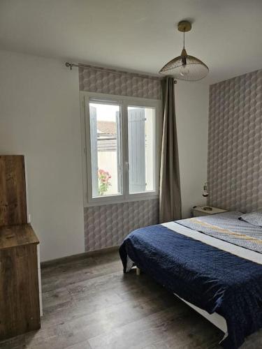 une chambre avec un lit bleu et une fenêtre dans l'établissement Jolie maison neuve avec piscine, à Esnandes