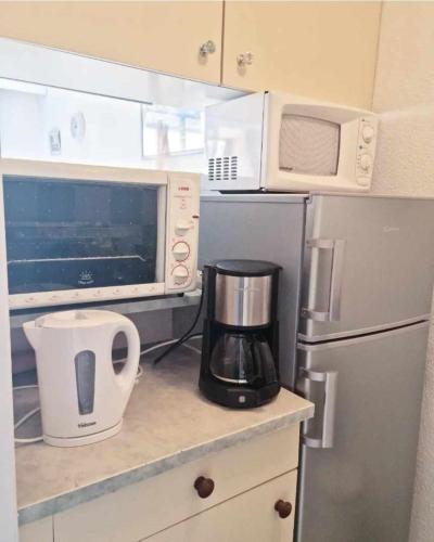 une cuisine avec un four micro-ondes et un mixeur sur un comptoir dans l'établissement Appart lumineux Piscine Parking, au Cap d'Agde