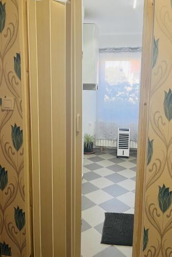 an open door to a room with a checkerboard floor at Téesz Vendégház in Zalaháshágy