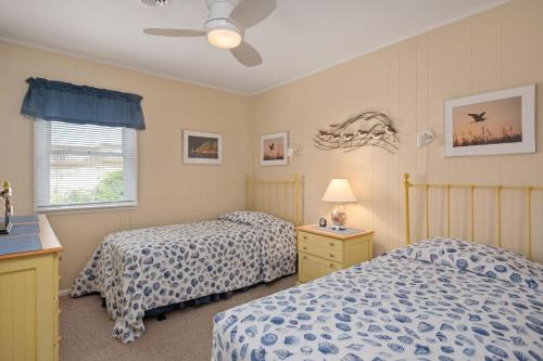 een slaapkamer met twee bedden en een plafondventilator bij SNH448 L'il Seabreeze in Nags Head