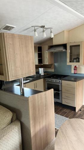 a large kitchen with wooden cabinets and a table at Wild Atlantic Way Stay Carrigart in Donegal