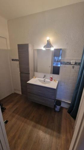 une salle de bain avec un lavabo et un miroir dans l'établissement Appartement en bord de plage - à 50 m de la mer, à Canet