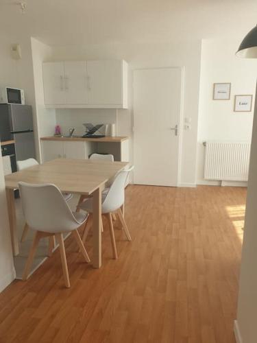 une cuisine avec une table et des chaises dans une pièce dans l'établissement Appart F2 proche aéroport Orly, à Morangis