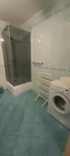 a bathroom with a shower and a washing machine at Apartament w centrum Pobierowa blisko plaży in Pobierowo