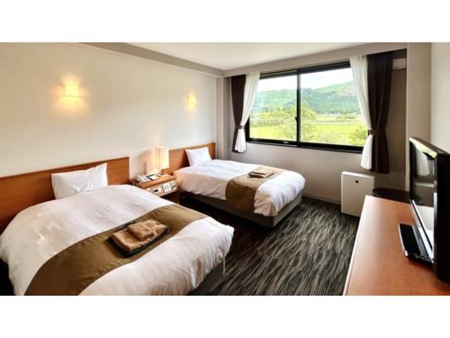 a hotel room with two beds and a large window at Aso Hakuun Sanso - Vacation STAY 77860v in Aso