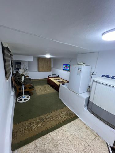 a small room with a refrigerator and a bedroom at misafir yeri in Kerak