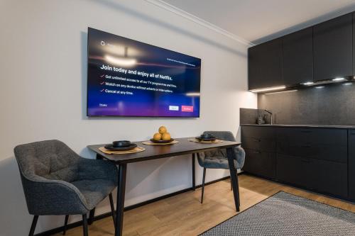 a kitchen with a table and two chairs and a tv at Elegant 28m2 Studio Flat 3min Walk from Old Town in Tallinn