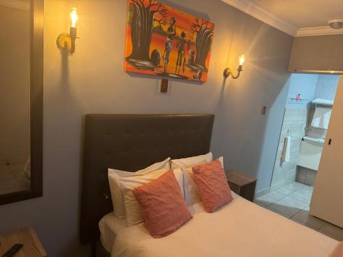 a bedroom with a bed with two pillows on it at Kv Luxury Guest House in Johannesburg