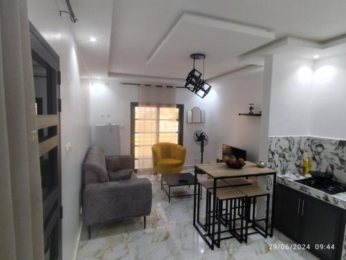 a kitchen and living room with a table and chairs at Appartement meublé Thiès in Thiès