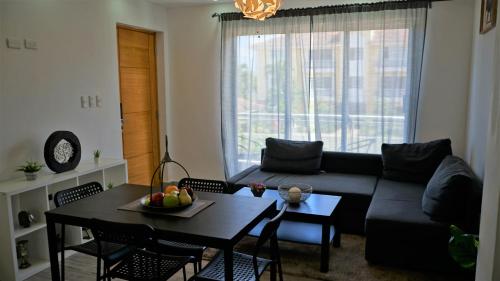a living room with a black couch and a table at La Yarolina in Punta Cana