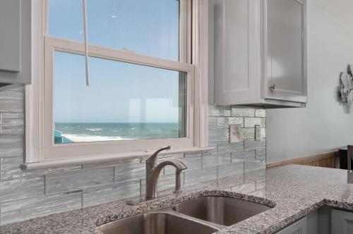 een keuken met een spoelbak en een raam bij SNH249 SeaAira in Nags Head