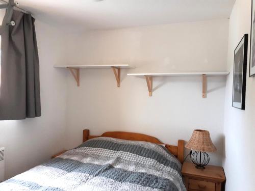 - une chambre avec un lit et des étagères sur le mur dans l'établissement Chalet Arrondaz - 2 Pièces pour 6 Personnes MAE-8674, à Modane