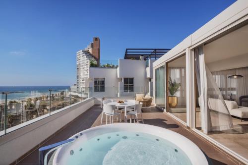 a hot tub on a balcony with a view of the ocean at Jewel TLV Hotel in Tel Aviv