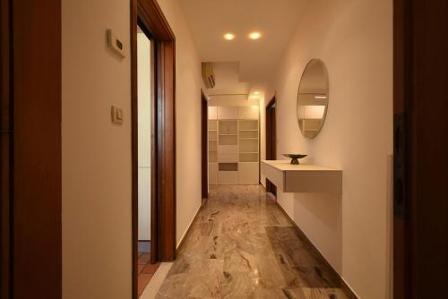 a hallway of a bathroom with a sink and a mirror at Welc-oM Deluxe next to Pra della Valle in Padova