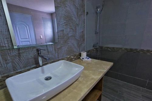 a bathroom with a white sink and a shower at La Yarolina in Punta Cana
