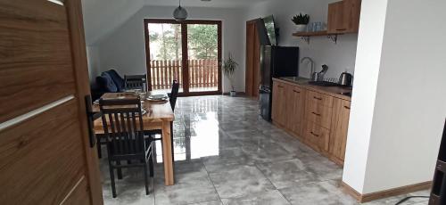 a kitchen with a wooden table and a dining room at Roztoczańska Przystań in Majdan Sopocki