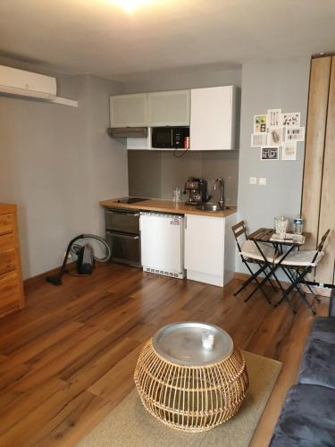 un salon avec une table et une cuisine dans l'établissement L'Amazone Studio 25m2 Wifi climatisé avec loggia, à La Grande Motte