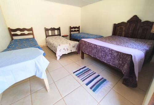 Habitación con 2 camas, 2 sillas y alfombra. en Rancho Vale Verde, en Governador Valadares
