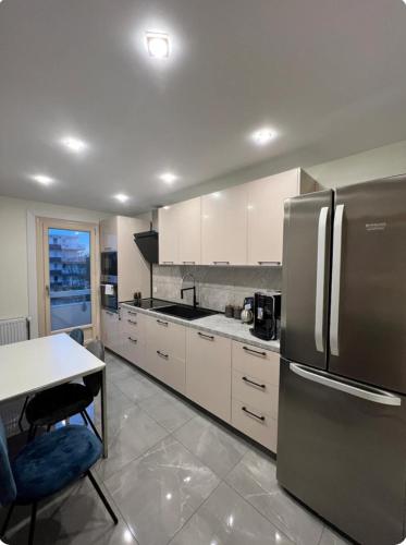 une cuisine avec un réfrigérateur en acier inoxydable et une table dans l'établissement Brv appart, à Angers