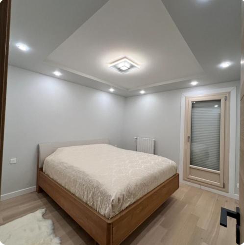 une chambre blanche avec un lit et une fenêtre dans l'établissement Brv appart, à Angers