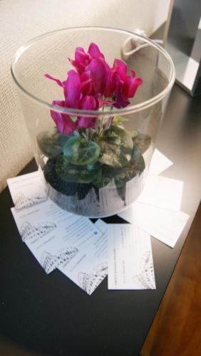 a vase filled with pink flowers on a table at Catia Sweet Holiday 2 in Fiumicino