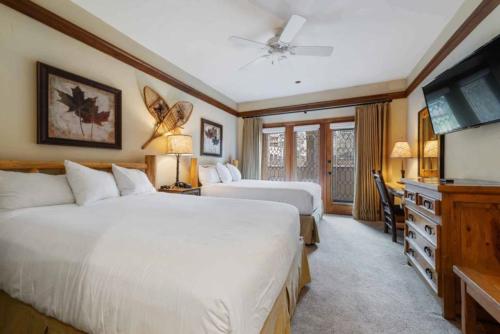 Un dormitorio con dos camas y un televisor de pantalla plana. en The Charter at Beaver Creek E115, en Beaver Creek