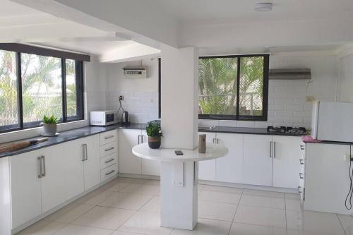 a kitchen with white cabinets and a table in it at Kianna Apartments in Mba