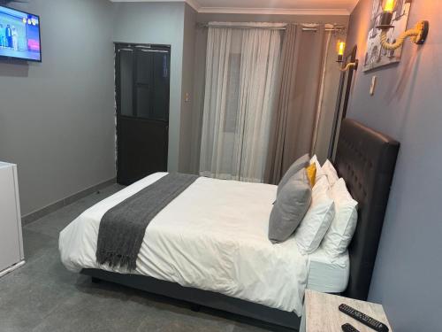a bedroom with a bed and a television in it at Kv Luxury Guest House in Johannesburg