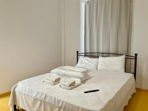 a bed with two towels and a remote control on it at BARBAGIANNIS Stoupa in Stoupa