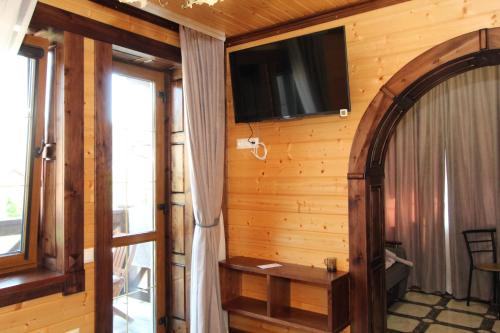 a room with a tv on a wooden wall at Бесаги in Yaremche