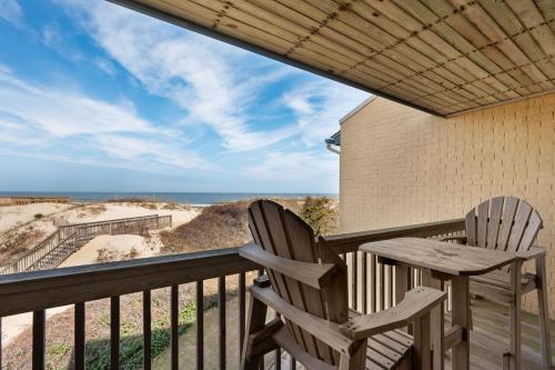 two chairs on a balcony with a view of the beach at QA4 Coastal Comfort in Nags Head
