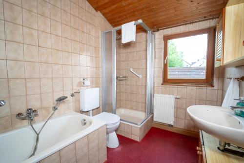 a bathroom with a tub and a toilet and a sink at RANGE - Landhaus mit Panoramablick - 2 Apartments - Parkplatz - Küche - WLAN - Monteure 1-11 Personen in Winterbach