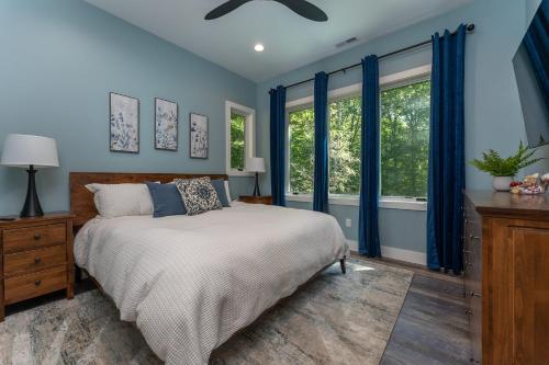 a bedroom with a bed with blue walls and windows at The Creeks of Serendipity in Black Mountain