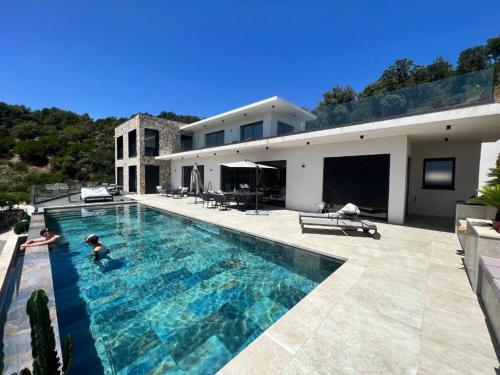 une piscine devant une maison dans l'établissement villa vue mer « golf St Tropez » les issambres, aux Issambres