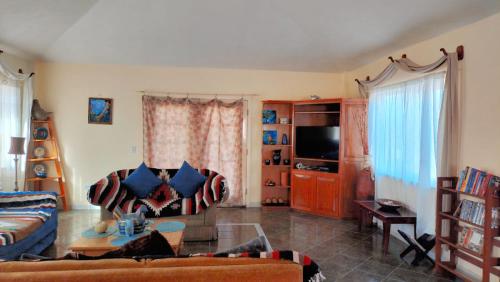 a living room with a couch and a tv at Casa Grande - Coco Cabanas Loreto in Loreto