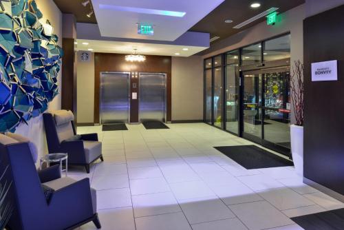 a lobby of a building with chairs and windows at Courtyard by Marriott Wilmington Downtown/Historic District in Wilmington