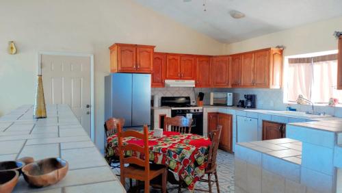 cocina con mesa y nevera azul en Casa Grande - Coco Cabanas Loreto, en Loreto
