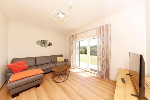 a living room with a couch and a tv at Wo sich Kuh, Fuchs und Hase gute Nacht sagen in Wolfsegg